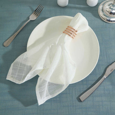 White napkin elegantly styled on a plate with decorative napkin ring.