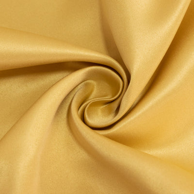 Shiny golden fabric in a swirling pattern.