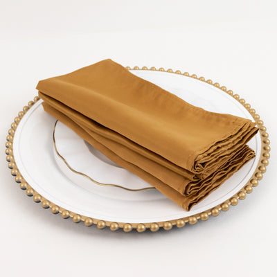 Brown napkins neatly folded on a decorative plate.