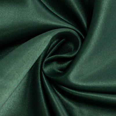 Luxurious dark green satin fabric close-up texture.