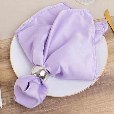 Lavender satin napkin with silver ring on a white plate