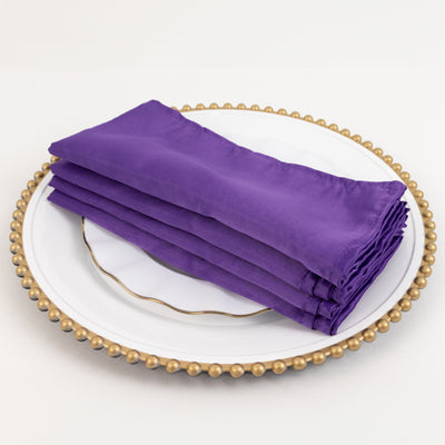 Stack of elegant purple napkins on a decorative plate
