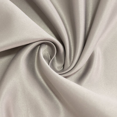 Silky beige fabric with a smooth texture, elegantly twisted.