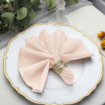 Elegant pink napkin with a silver napkin ring on a decorative plate.