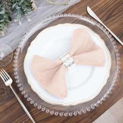 Elegant table setting with a pink napkin and decorative plate.