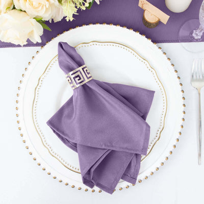 Purple napkin with decorative ring on an elegant plate setting.