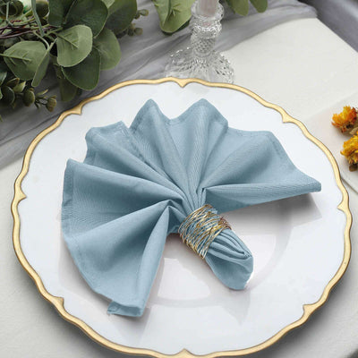 Blue fabric napkin elegantly arranged on a decorative plate.