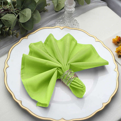 Green fabric napkin elegantly arranged on a decorative plate.