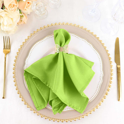 Green napkin elegantly folded on a decorative plate with gold accents.