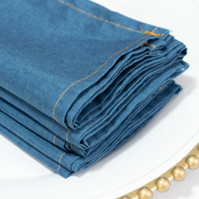 Folded blue denim napkins stacked neatly on a plate.