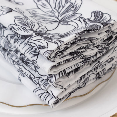 Floral-patterned napkins stacked on a white plate.