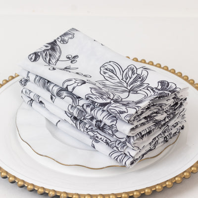 Floral patterned napkins neatly stacked on a decorative plate.