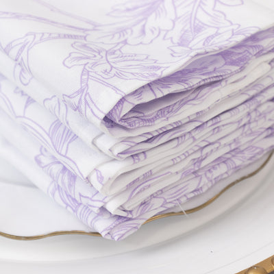 Folded lavender floral napkins stacked on a plate.