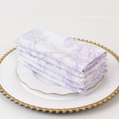 Stack of floral patterned napkins on a decorative plate.