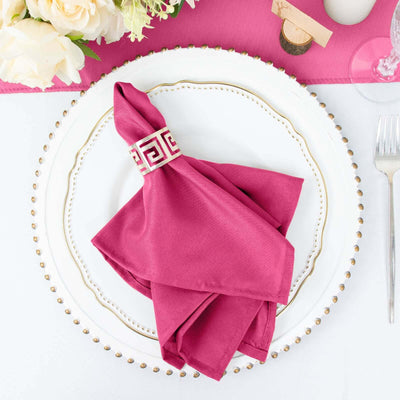Elegant fuchsia napkin with a decorative ring on a white plate