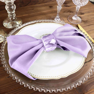 Purple satin napkin tied with a crystal napkin ring on an elegant dinner plate.