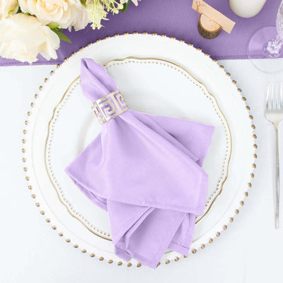 Purple napkin elegantly folded with a decorative napkin ring on a white plate.