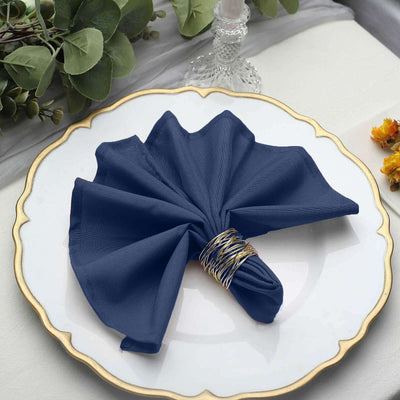 Navy blue napkin elegantly folded on a decorative plate.