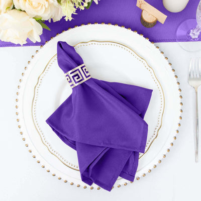 Purple napkin elegantly styled on a decorative plate with floral arrangement.