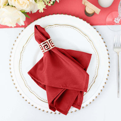 Red napkin elegantly folded on a decorative plate for dining setting.