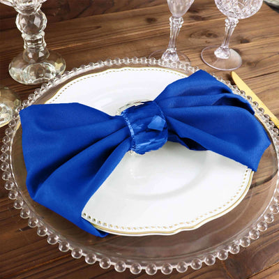 Blue fabric napkin elegantly tied on a white plate setting.