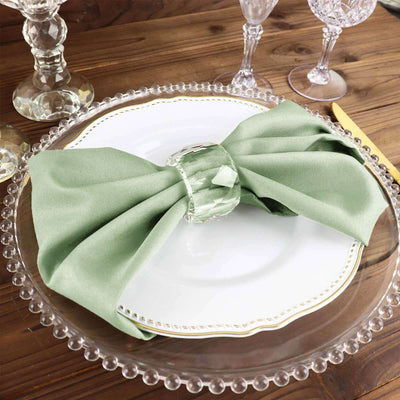 Elegant green napkin with crystal ring on a decorative plate.