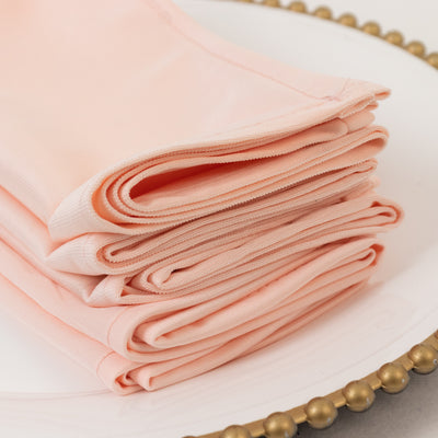 Folded peach fabric neatly arranged on a decorative plate.
