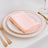 Pink napkin folded on elegant dinner plate with gold trim.