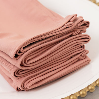 Folded rose-colored fabric on a decorative plate.
