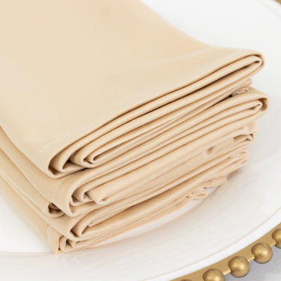 Folded beige napkins stacked neatly on a plate.
