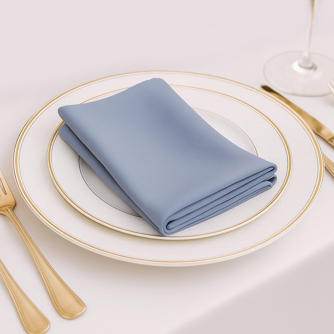 Elegant blue napkin folded on a fine dining plate setting.
