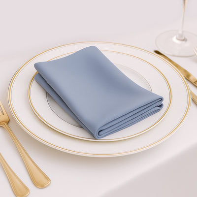Elegant blue napkin folded on a fine dining plate setting.