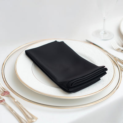 Black napkin neatly folded on an elegant plate with silver cutlery