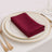 Burgundy napkin elegantly folded on a fine dining plate