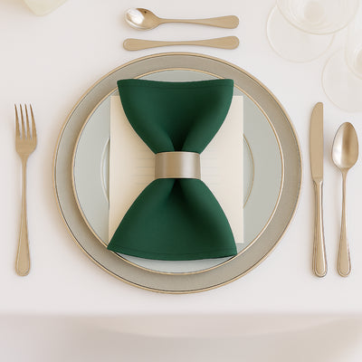 Elegant green napkin with silver holder on a stylish dining plate setting.