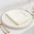 Elegant cream napkin neatly folded on a decorative plate.