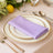 Lavender napkin elegantly folded on a decorative plate at a dining table.