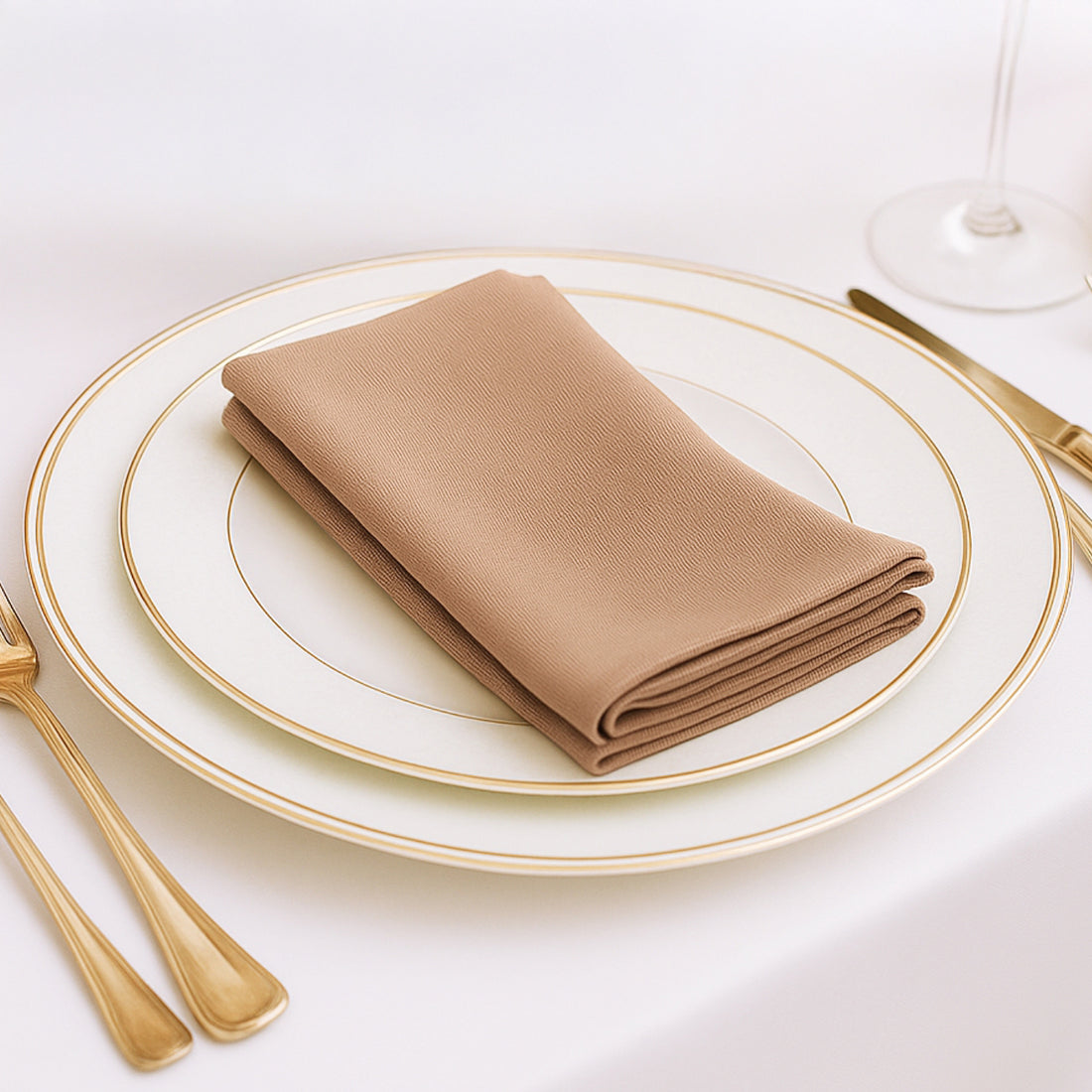 Elegant beige napkin neatly folded on a fine dining plate setting.