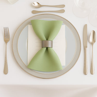 Elegant green napkin with silver ring on a fine dining plate.