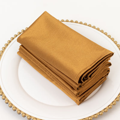 Stack of elegant gold napkins on a decorative plate