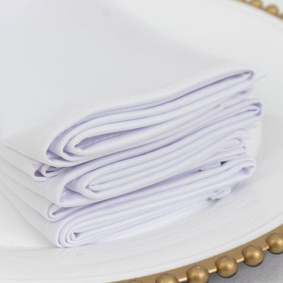 Stack of elegant white napkins on a decorative plate.