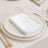 Elegant white napkin folded on a fine china plate with gold accents.