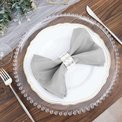 Elegant gray napkin bow on a decorative plate, set on a wooden table.