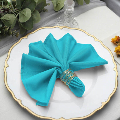 Turquoise napkin elegantly arranged on a decorative plate.