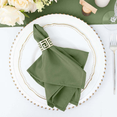 Green napkin with decorative band on an elegant plate setting.