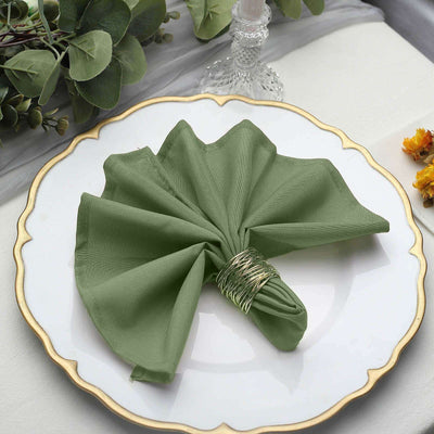 Green fabric napkin elegantly arranged on a decorative plate.