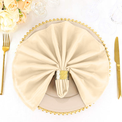 Elegant beige napkin elegantly arranged on a decorative plate with a golden rim.