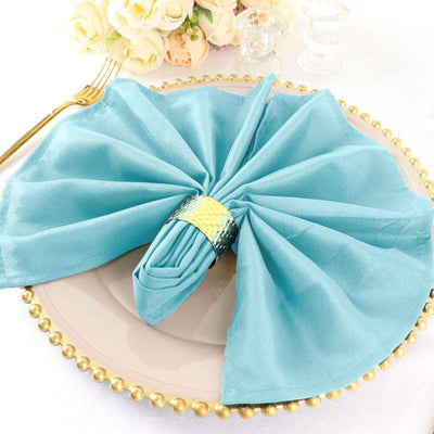 Turquoise napkin elegantly arranged on a decorative plate.