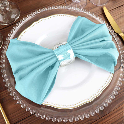 Elegant turquoise napkin bow on a decorative plate setting.