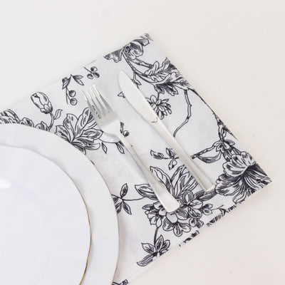 Floral-patterned placemat with plate and cutlery on a neutral background.
